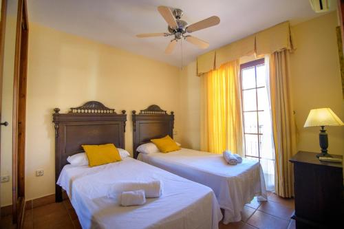 a bedroom with two beds and a ceiling fan at Mediterranea 10 tus momentos junto al mar Villaricos in Cuevas del Almanzora