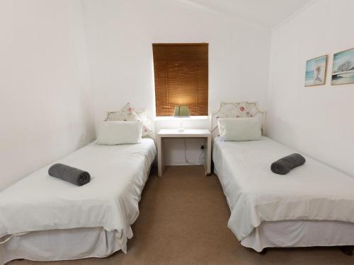 two twin beds in a room with a sink at Ramsgate Beach Club in Ramsgate
