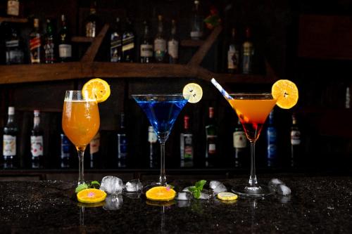 a group of four cocktails sitting on a bar at Jungle Villa Resort - Near Chitwan National Park in Chitwan