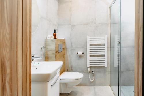 a bathroom with a toilet and a sink and a shower at Villa & Gospoda Krakowska in Kobiernice