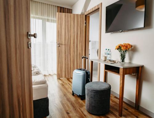 a hotel room with a desk and a suitcase at Villa & Gospoda Krakowska in Kobiernice