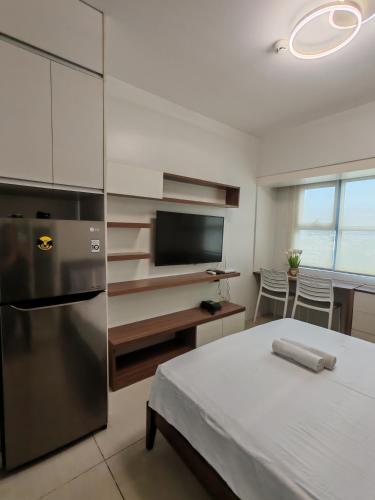 a kitchen with a bed and a television in a room at Lourdes Bedsit Horizon 101 in Cebu City