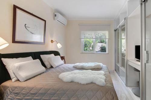 a bedroom with a bed and a tv on a wall at Celestial Blue Vale Do Lobo in Almancil