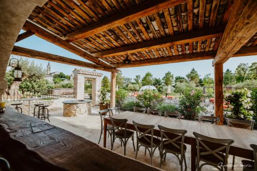 a patio with a long wooden table and chairs at Domaine de coulette in Vallon-Pont-dʼArc