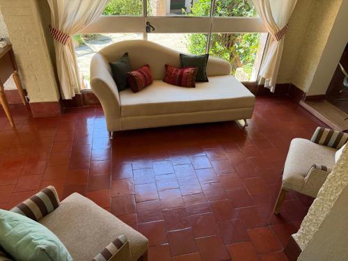 a living room with a couch and two chairs at Posada los Cedros in La Cumbre