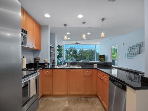 a kitchen with brown cabinets and a large window at Luxurious 2 Beds 2 Baths Downtown Apartment in Orlando