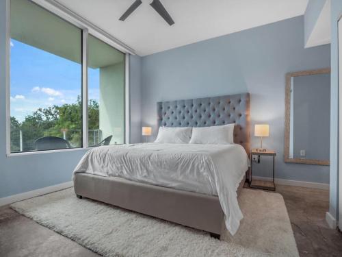 a bedroom with a large bed and a large window at Luxurious 2 Beds 2 Baths Downtown Apartment in Orlando