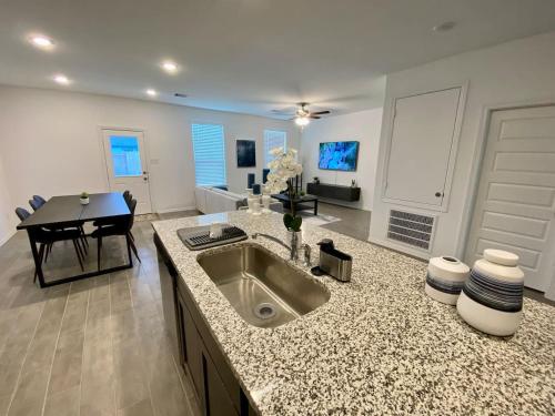 a kitchen with a sink and a living room at 4-BR Cheerful Home Long Term Stay Equipped in Katy in Katy