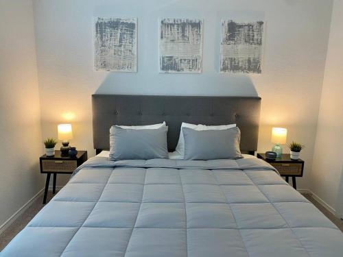 a bedroom with a large white bed with two lamps at 4-BR Cheerful Home Long Term Stay Equipped in Katy in Katy