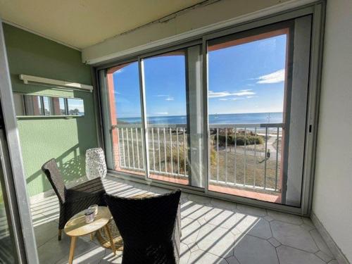 un balcon avec une table et des chaises et une vue sur l'océan dans l'établissement 074 Plein Sud A1-22, au Cap d'Agde