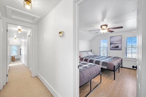Un dormitorio con dos camas y un ventilador de techo. en Vintage 8BR Farmhouse With Hot Tub Spacious Yard, en Port Colborne
