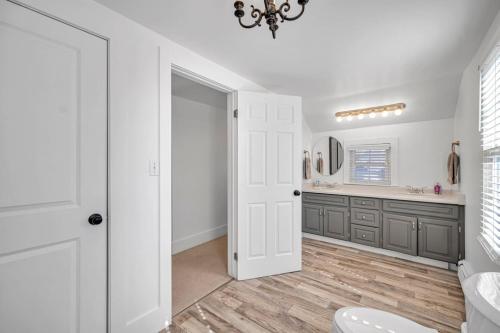 Un baño con inodoro, lavabo y espejo. en Vintage 8BR Farmhouse With Hot Tub Spacious Yard, en Port Colborne