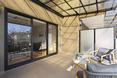 a screened in porch with a couch and a table at Domi Rentals The Chadstone Homes in Chadstone