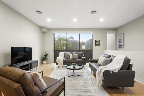 a living room with a couch and a tv at The Brighton Townhouse in Melbourne