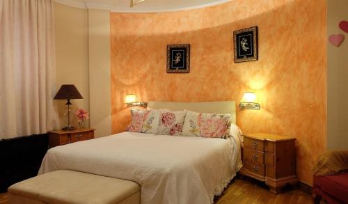 a bedroom with a white bed with two night stands at villa mijas with pool 50 m beach in Fuengirola