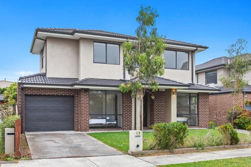 a brick house with a garage at Domi Rentals - The Jaguar Home in Clayton North
