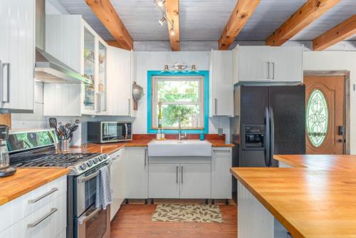 a kitchen with white cabinets and a sink at Secluded Cabin with Quality Furnishing and Hot Tub in Leicester