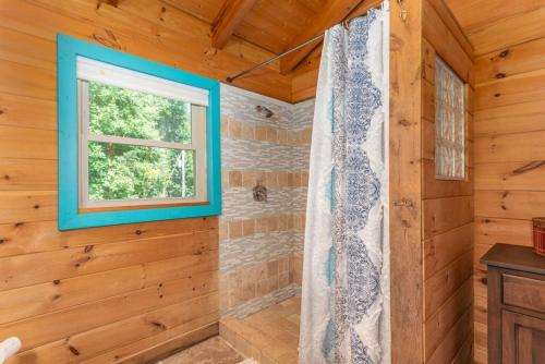 a bathroom with a window and a shower curtain at Secluded Cabin with Quality Furnishing and Hot Tub in Leicester