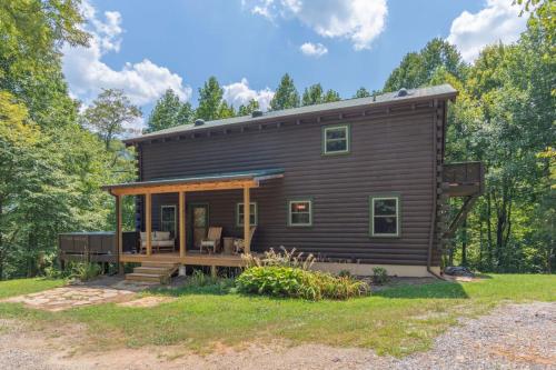 a cabin in the woods with a wrap around porch at Secluded Cabin with Quality Furnishing and Hot Tub in Leicester