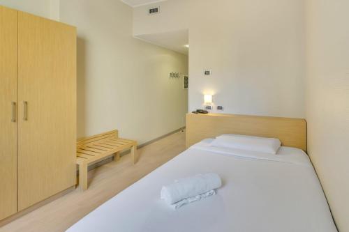 a bedroom with a white bed and a wooden cabinet at B&B HOTEL Milano La Spezia in Milan