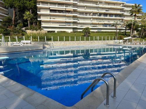 une grande piscine devant un immeuble dans l'établissement Studio SUPER Cannes résidence 