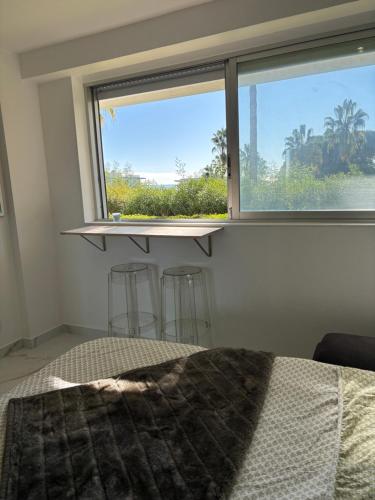 une chambre avec un lit et une fenêtre avec vue dans l'établissement Studio SUPER Cannes résidence 