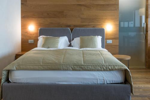 a bedroom with a large bed with white pillows at Sottovento Luxury Hospitality in Bormio