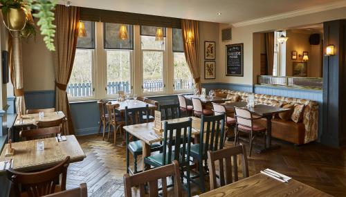 a restaurant with tables and chairs and windows at Craigside Manor in Llandudno