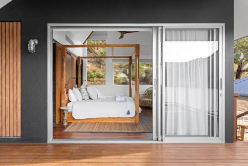 a bedroom with a bed and a sliding glass door at Pagoda Point in Bar Point