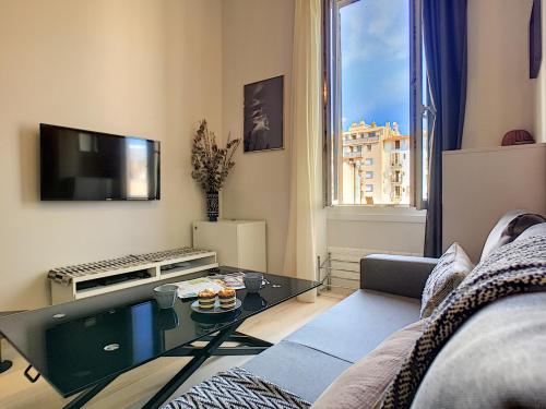 un salon avec un canapé et une télévision dans l'établissement Nestor&Jeeves - VOGUE BEACH - Central - Near Beach, à Nice