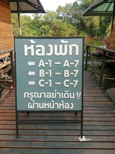 a sign with writing on it on a dock at มาตาบุรี ริเวอร์เเควรีสอร์ท in Ban Gaeng Cho