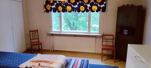 a bedroom with a bed and two chairs and a window at Spacious Apartment for 8 with Sauna in Sievi