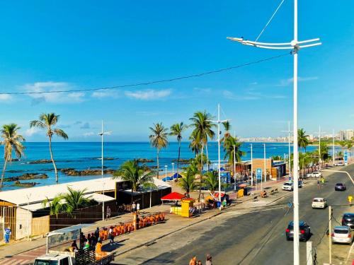 a city street with palm trees and the ocean at Hotel Bela Vista in Salvador