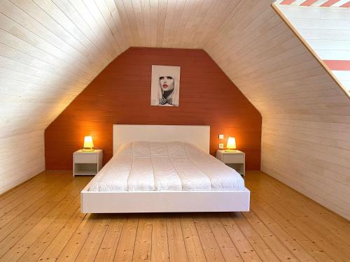 une chambre avec un lit et deux tables de nuit avec lampes dans l'établissement Maison avec WIFI, jardin clos et terrasse, à 500m de la mer et du GR34, Île Grande - FR-1-368-13, à Pleumeur-Bodou