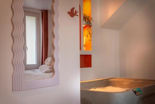 a bathroom with a mirror and a bath tub at Les Suites C&S in Aufferville