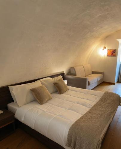 een slaapkamer met een groot bed en een bank bij Bellavita Rooms-Matera Arco 34 in Matera