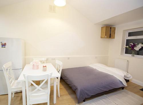 a bedroom with a bed and a table and chairs at Lovely 1-Bedroom Flat in London near Blackhorse Rd in London