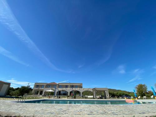 a building with a swimming pool in front of a building at Vians Olympia Resort in Olympia
