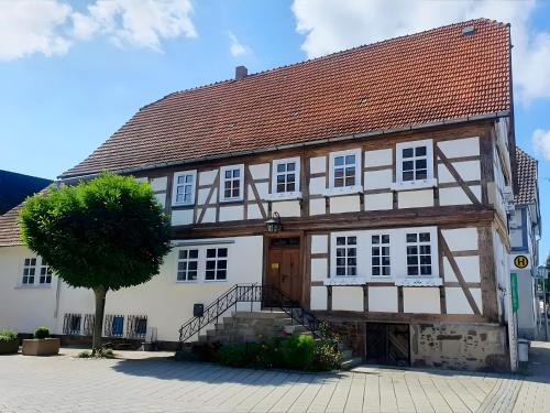 a white building with a tree in front of it at Zeihäänger Stubb in Schwalmstadt
