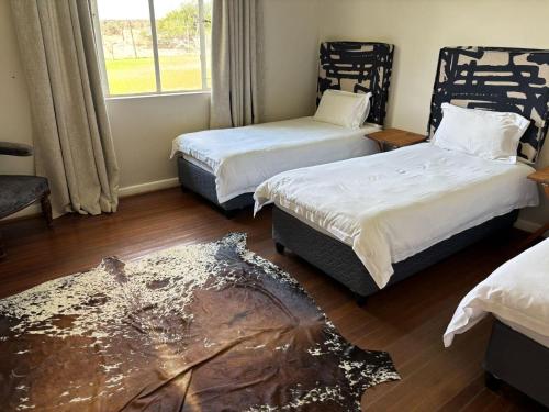 a room with two beds and a window at Pretoriuskuil in Aberdeen