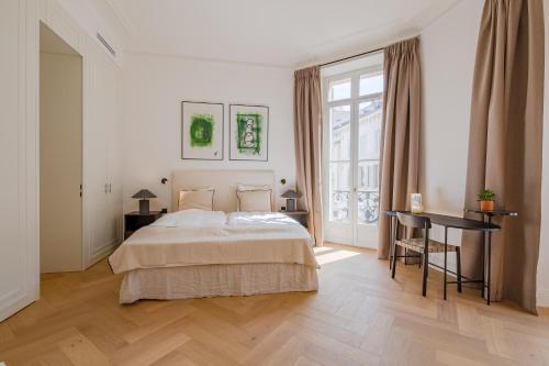 une chambre avec un lit, un bureau et une fenêtre dans l'établissement La Guitare 22 - Spacious 1 BR apartment in the center of Cannes, right behind Grand Hotel, à Cannes