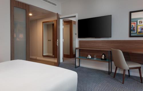 a hotel room with a bed and a television at Hampton By Hilton Edinburgh Airport in Ingliston
