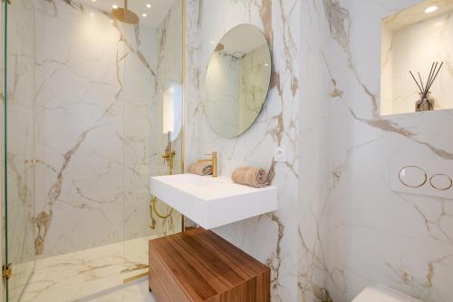 une salle de bain avec un lavabo et un miroir dans l'établissement La Guitare 22 - Spacious 1 BR apartment in the center of Cannes, right behind Grand Hotel, à Cannes