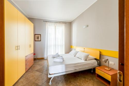 a bedroom with a white bed and a window at Residence Due Spade - Free Parking in Melzo
