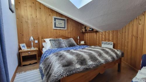 モリヨンにあるAlpen Marvelの木製の壁とベッドのある寝室