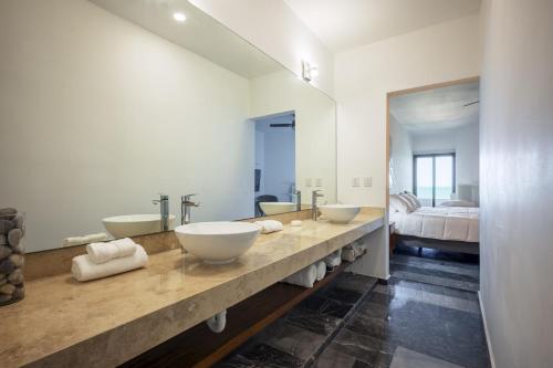 a bathroom with two sinks and a large mirror at The Ocean Breeze Getaway at BocaMar in Uaymitun