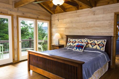 Un dormitorio con una cama en una habitación con ventanas. en Belle Ridge, en Blue Ridge