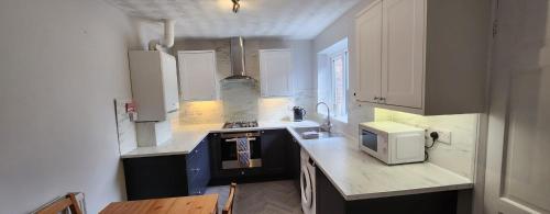 a kitchen with a counter top with a microwave at Sea Glass Cottage in Sunderland