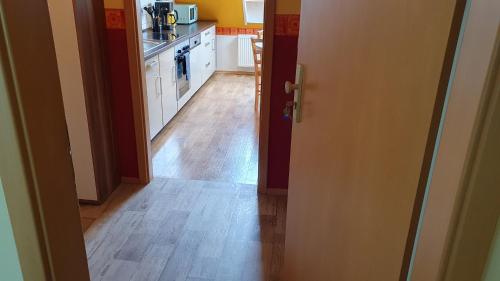 an open door to a kitchen with a wooden floor at Ferienwohnung im Gutshof Direkt gegenüber dem Schloss, Rhododendronpark mit Terrasse und WLAN in Kromlau