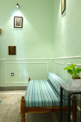 a striped bench with a table and a potted plant at House of Amer in Jaipur